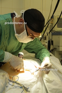 Последний этап операции. Хирург зашивает крошечный разрез после робот- ассистированной операции 